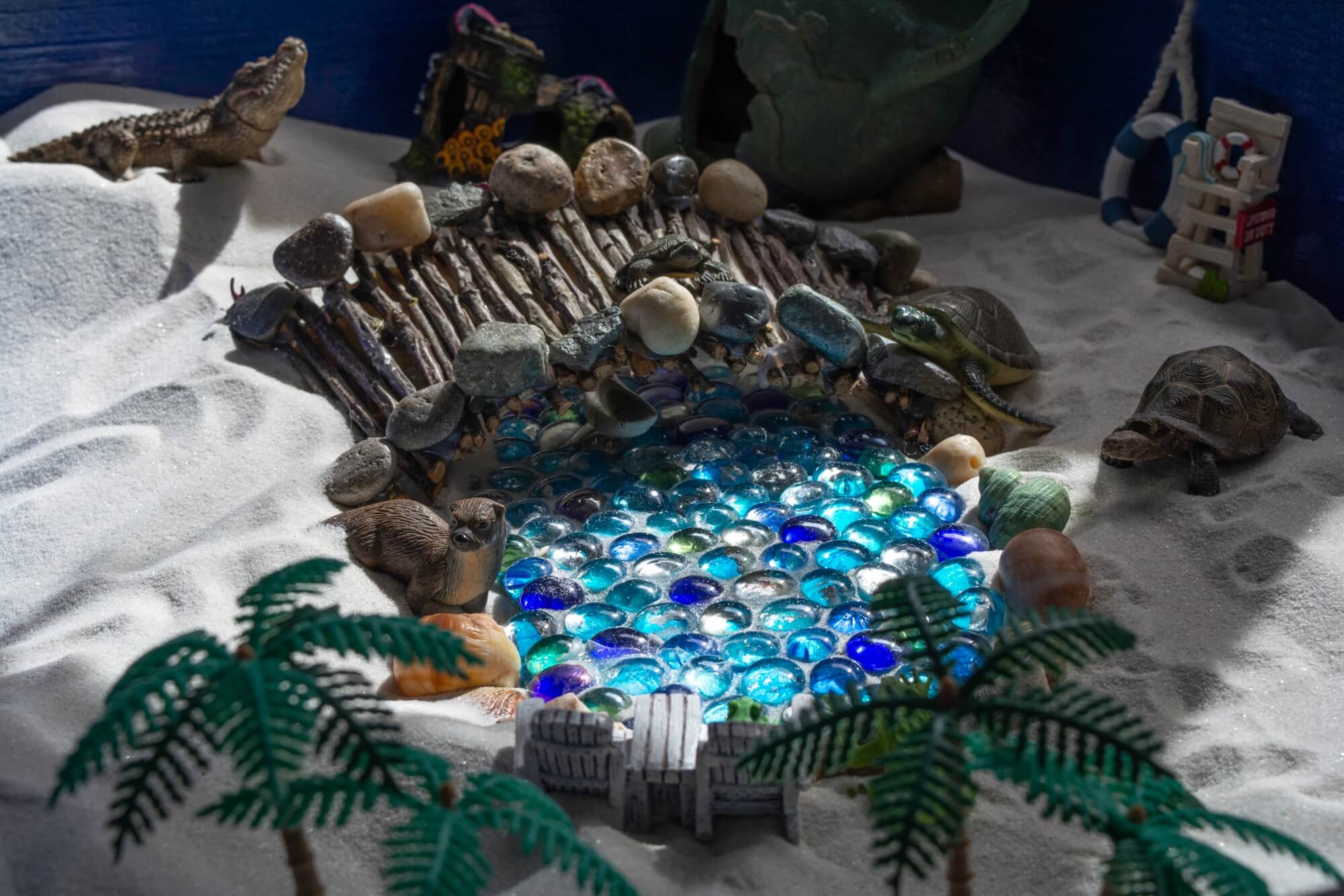 Sea themed miniatures in a sand tray