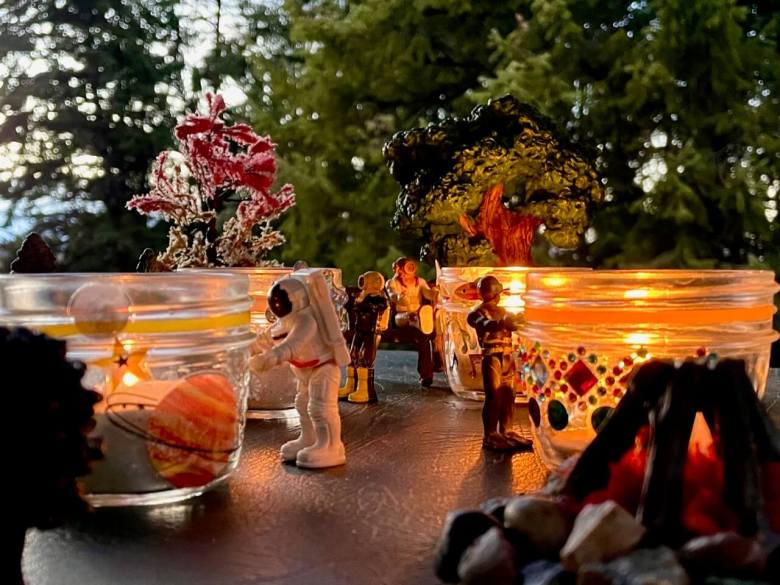 Small toys looking at their Memory Lanterns in nature