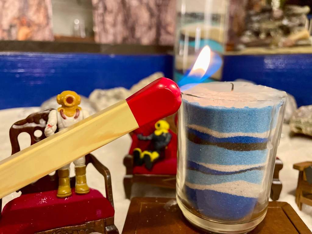 Small toy lighting the candle on top of the Layers of Love