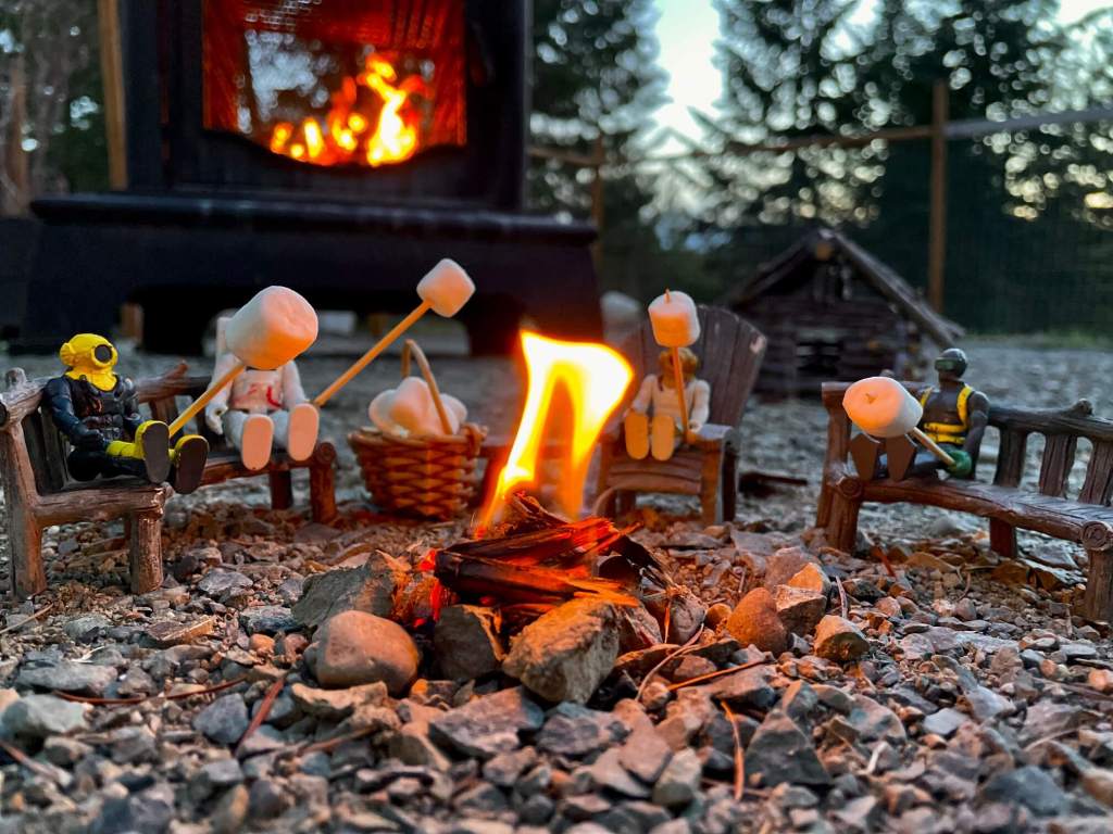 Toys sitting around a campfire roasting marshmallows 