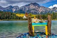 Toys sitting on a dock of a lake talking and fishing