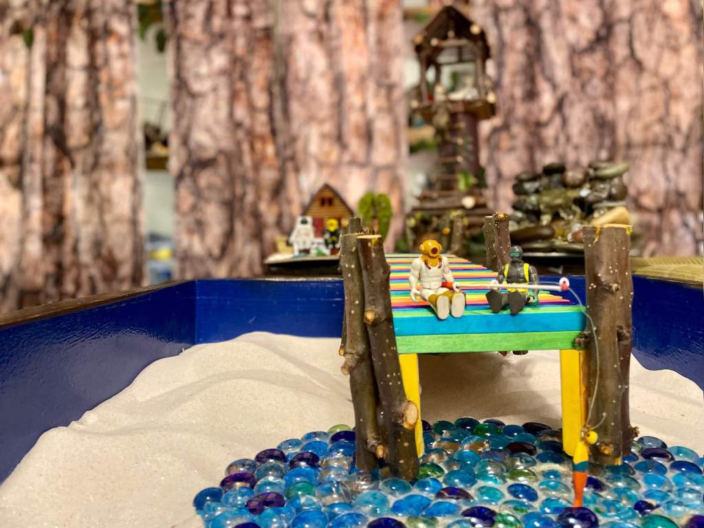 Toys sitting on a dock talking and fishing 