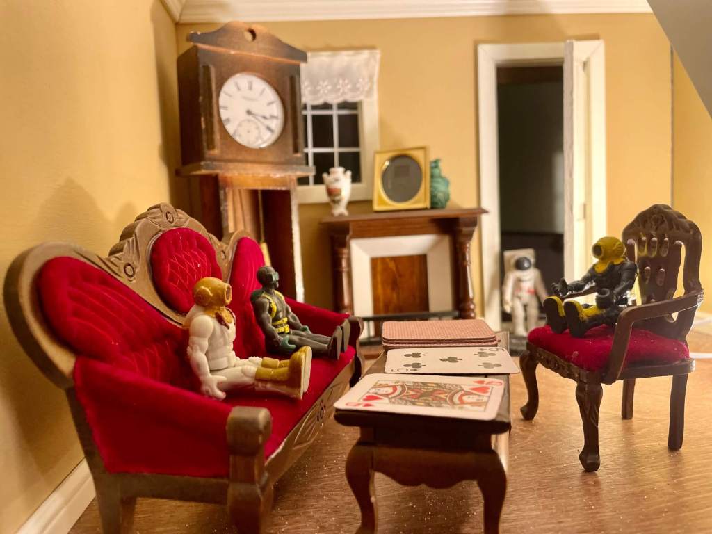 A toy walks in the front door while other toys are playing a card game