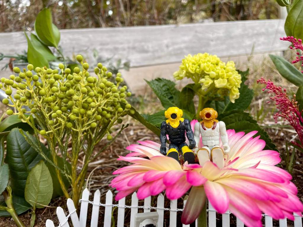 Toys talking and sitting on top of a flower