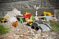 Toys hammering concrete and using construction vehicles