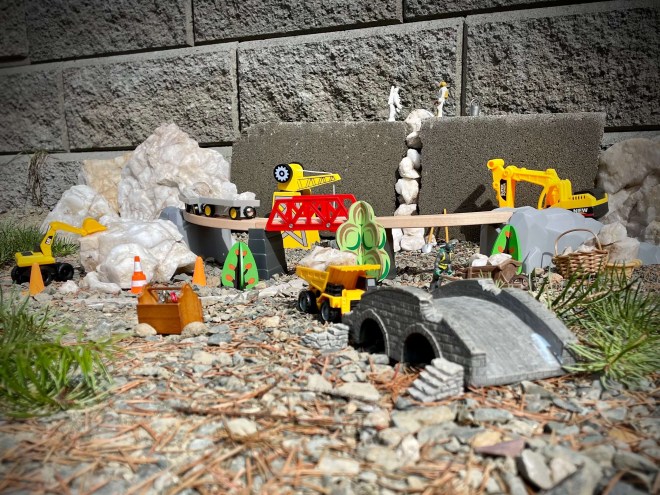Toys hammering concrete and using construction vehicles