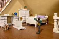 One small toy is knocking over some items in their room while another toy has their hands in the air