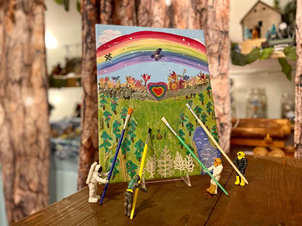 4 miniature toys painting one canvas with the image of Dallas’ Best Place Ever