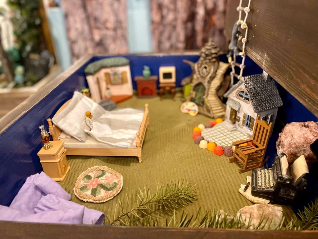 A scuba diving miniature is laying in bed in the space that is just for Dallas. Multiple doors go to the various spaces such as the arts and crafts studio