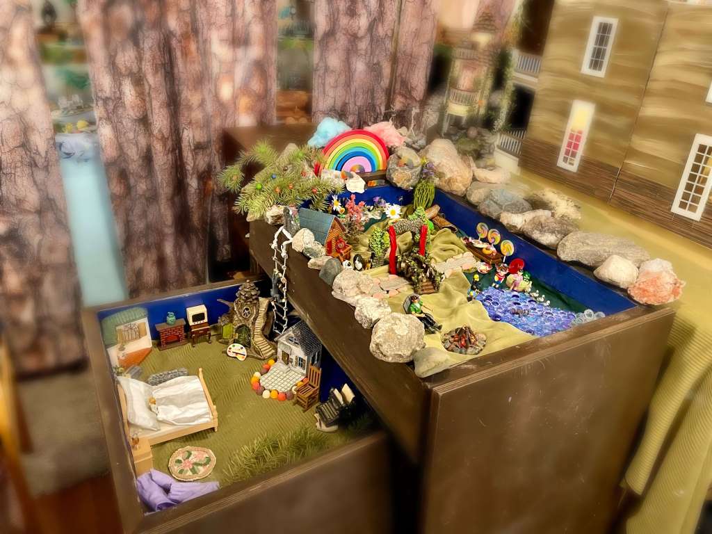 An image made of miniatures in two sand trays of Dallas’s Best Place Ever. The upper sand tray is the main space and the lower is the space just for Dallas