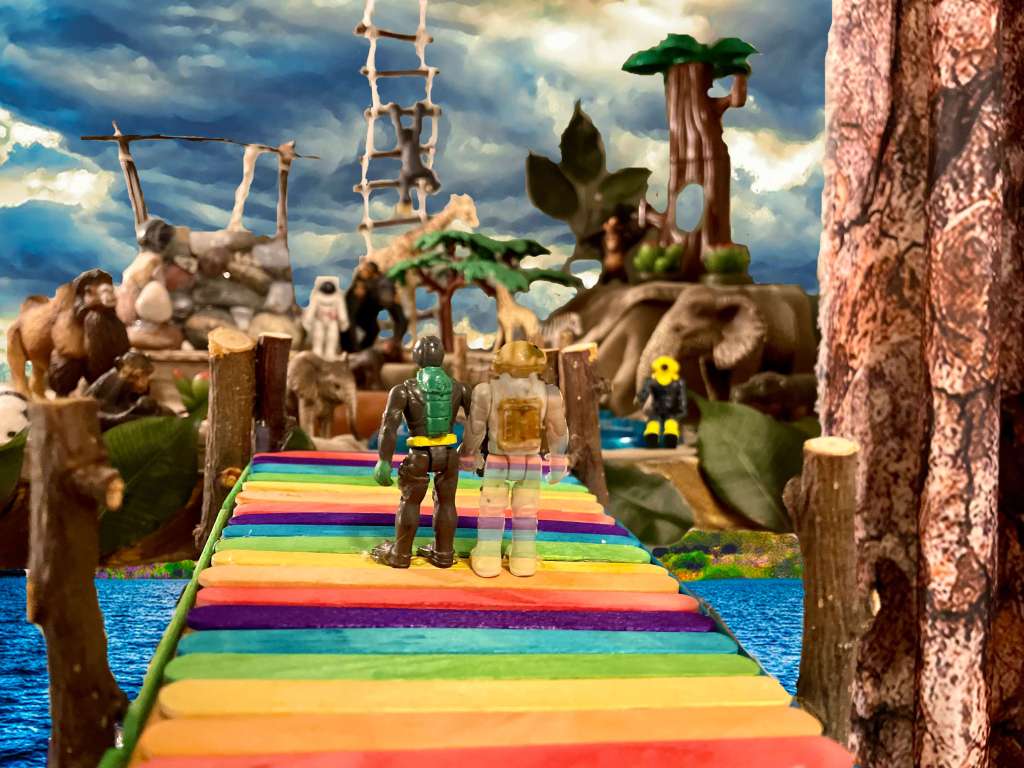 2 toys hand in hand on a rainbow dock, 1 toy is faded. In the back are 2 other toys, a wishing well, trees, and animals