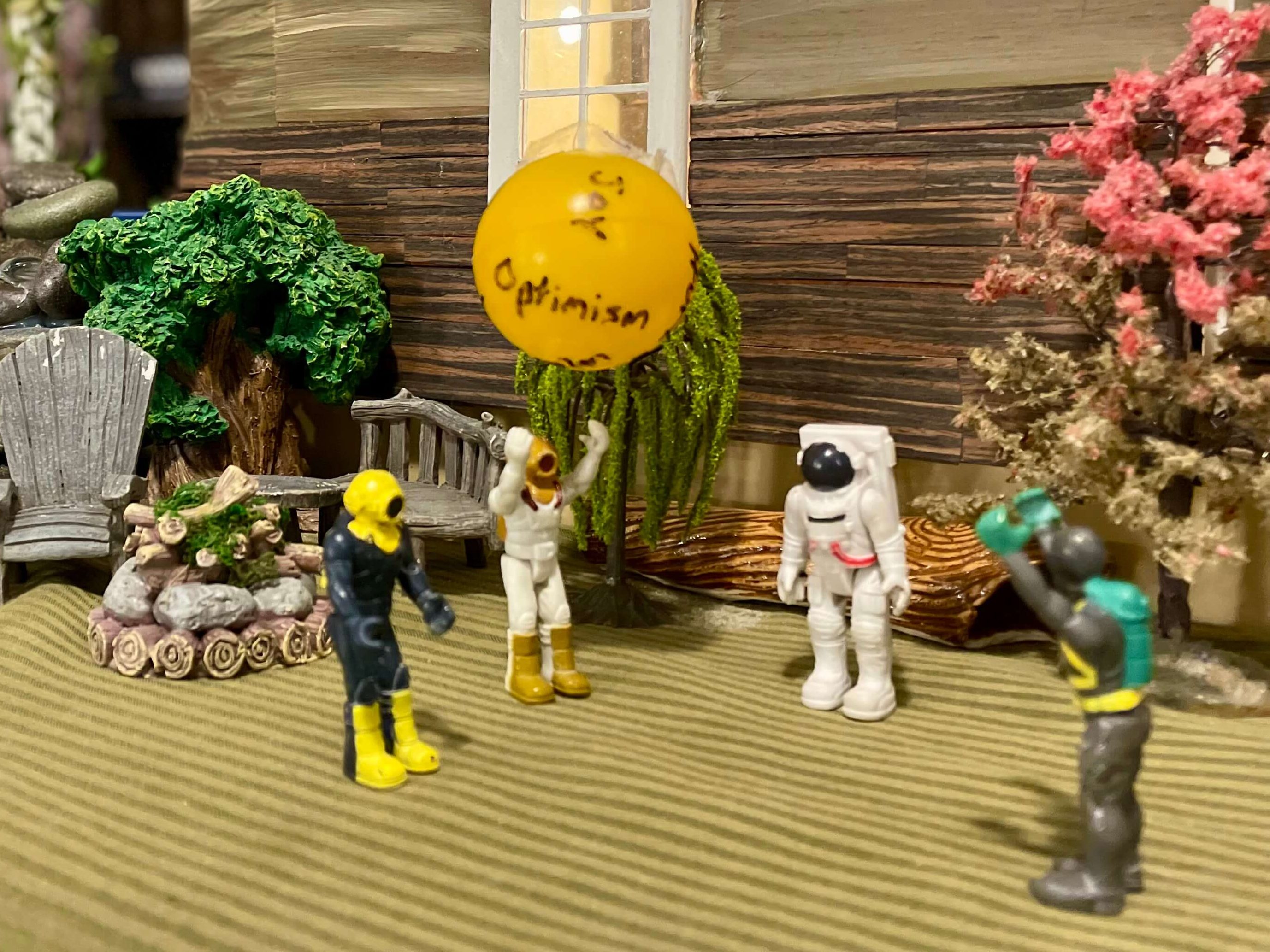 Small toys throwing a beach ball with emotion words written in the ball